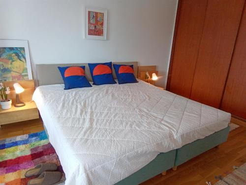 a bedroom with a bed with blue and orange pillows at Casa Melfer in Sesimbra