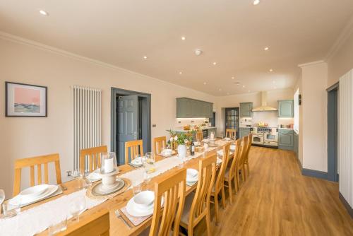 a large dining room with a long table and chairs at Llywelyn-Fawr in Aberffraw
