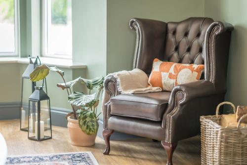 a leather chair with pillows in a living room at Llywelyn-Fawr in Aberffraw