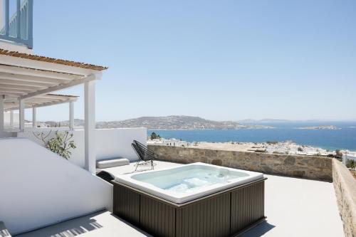 a hot tub on a balcony with a view of the ocean at Boho Origin Mykonos in Mýkonos City