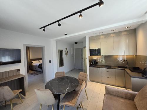 a kitchen and a living room with a table and chairs at Słoneczny Brzeg - Apartamenty w Pieninach in Krościenko