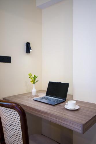 a laptop computer sitting on top of a wooden desk at Alaya Stays Premium 1 BHK - Baljees Melville Utopia in Shimla