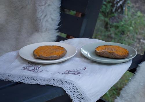 two pieces of cake on plates on a table at Glempings Eglenieki in Almale