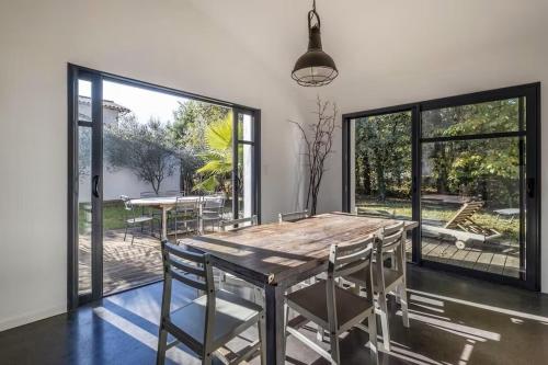 une salle à manger avec une table et des chaises en bois dans l'établissement Villa Taru La Palmyre, aux Mathes