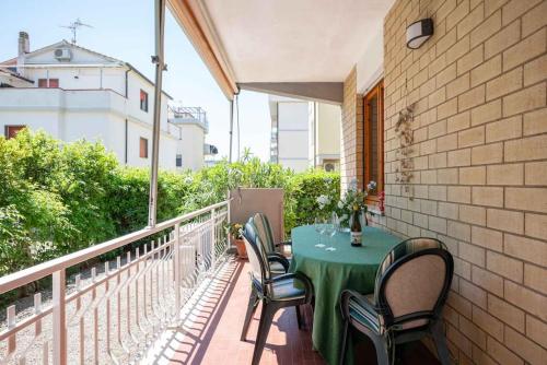 a green table and chairs on a balcony at Follonica Seahouse Vivi la Magia del Mare in Follonica