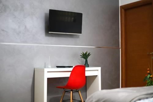 a red chair sitting next to a desk with a television at Casa Vacanze Le CIsterne in Gioia Tauro
