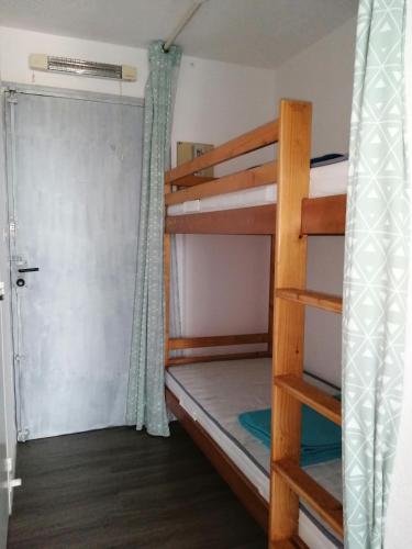 Cette chambre dispose de lits superposés et d'une porte. dans l'établissement Bel appartement 4 personnes dans résidence privée avec Parking, au Cap d'Agde