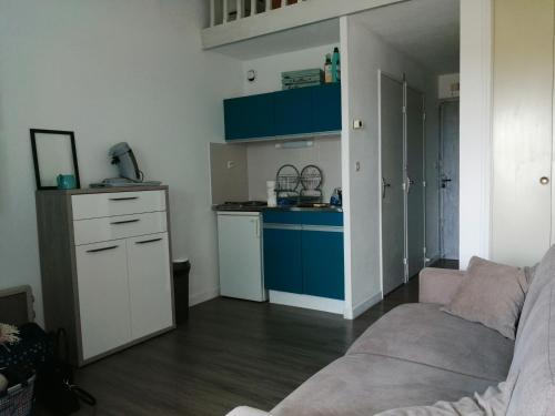 un salon avec un canapé et une cuisine dans l'établissement Bel appartement 4 personnes dans résidence privée avec Parking, au Cap d'Agde