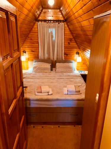 a bedroom with a bed in a wooden cabin at Lulu Cottage in Žabljak