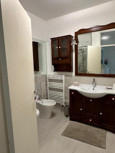 a bathroom with a sink and a toilet and a mirror at Albicocca in Falconara Marittima