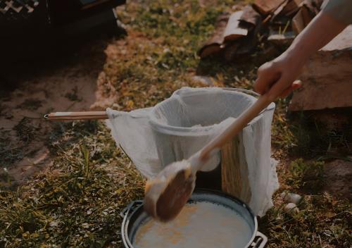 una persona sta mescolando una pentola con un cucchiaio di legno di Glempings Dīķīši a Stākas