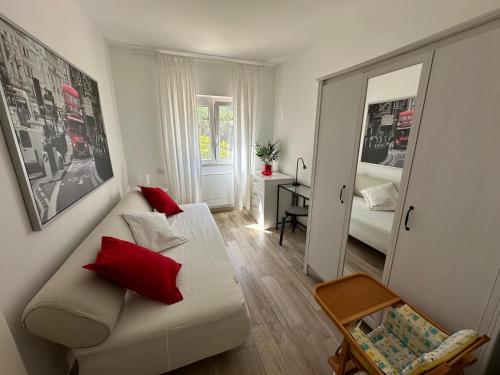 a living room with a white couch and red pillows at Albicocca in Falconara Marittima