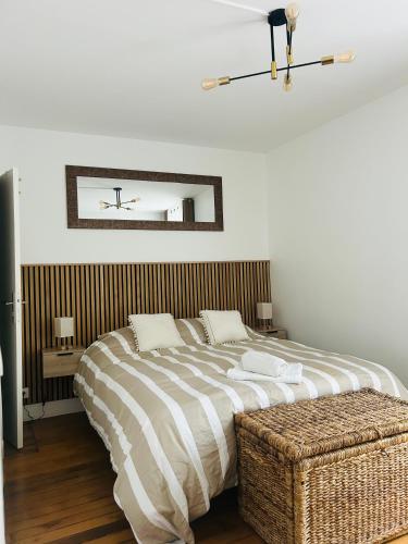 une chambre avec un grand lit et un miroir dans l'établissement Résidence Renan - Paris Porte de Versailles, à Issy-les-Moulineaux