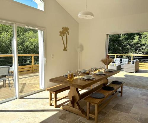 un salon avec une table en bois et une terrasse dans l'établissement Villa à deux pas du lac, à Léon