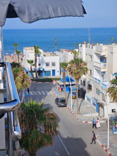 a view of a street with buildings and the ocean at Pink House Martil in Martil