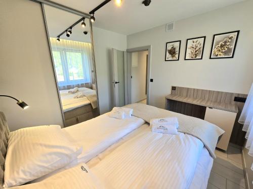 two beds in a room with a mirror at Słoneczny Brzeg - Apartamenty w Pieninach in Krościenko