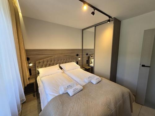 a bedroom with a bed with two towels on it at Słoneczny Brzeg - Apartamenty w Pieninach in Krościenko