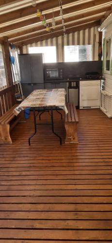 une cuisine avec une table et un banc sur un plancher en bois dans l'établissement Mobile home 613 6 à 8 pers 44m2 tout équipé, aux Mathes