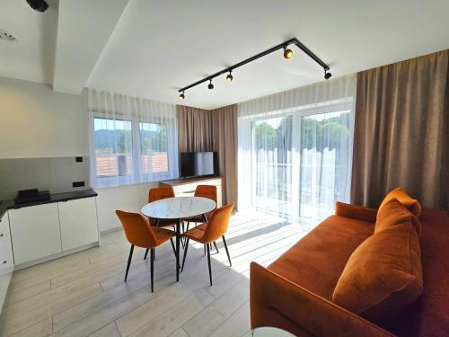 a living room with a couch and a table at Słoneczny Brzeg - Apartamenty w Pieninach in Krościenko