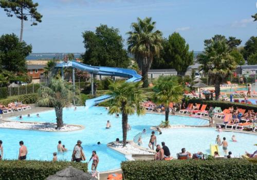 un groupe de personnes dans une piscine d'un complexe hôtelier dans l'établissement ESCALE BASSIN- Mobile Home Lège Cap-Ferret - Village 4 étoiles LES VIVIERS, à Lège-Cap-Ferret