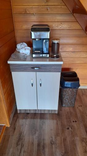 a kitchen with a counter with a coffee maker on it at Căbănuța Busuioc Colibita in Bistriţa Bîrgăului
