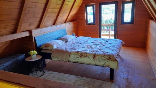 a bedroom with a bed in a wooden cabin at Căbănuța Busuioc Colibita in Bistriţa Bîrgăului