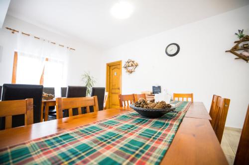 a dining room table with a bowl of fruit on it at Pensiunea Codruta in Carpinis