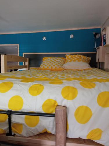 une chambre avec un lit à pois jaunes et jaunes dans l'établissement CHARMANT STUDIO à 2 pas de NAVAL GROUP au coeur d une rue commerçante, à Cherbourg en Cotentin