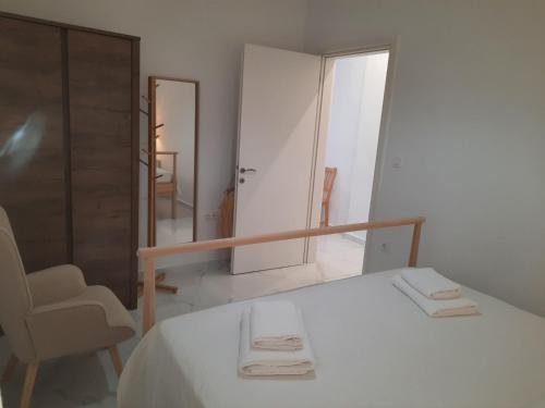a bedroom with a bed and a chair and a mirror at House B Diavata, Thessaloniki in Thessaloniki