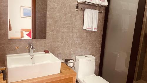 a bathroom with a white sink and a toilet at 古北御尚精品民宿Gubeiyushang in Gubeikou