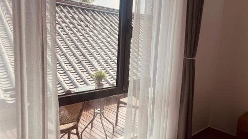 a room with a window with a plant on a balcony at 古北御尚精品民宿Gubeiyushang in Gubeikou
