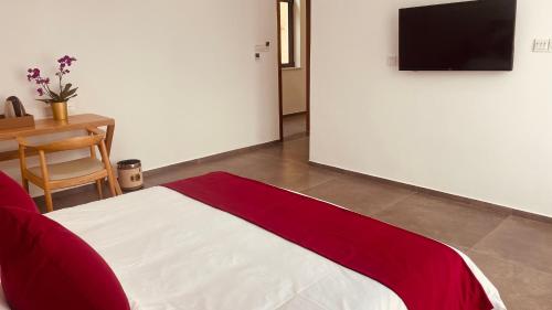 a bedroom with a red and white bed and a table at 古北御尚精品民宿Gubeiyushang in Gubeikou