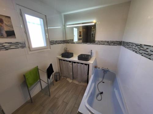 une salle de bain avec une baignoire, un lavabo et un miroir dans l'établissement Maison familiale avec piscine L Eucalyptus, à Malaucène