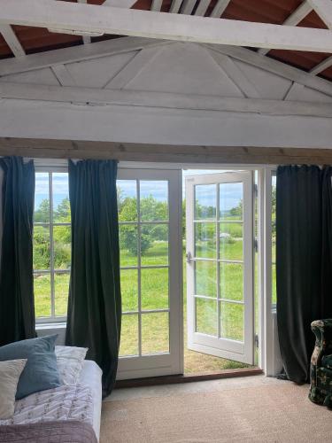 a bedroom with a bed and sliding glass doors at Camønogaarden B&B, darksky cabins and events in Borre