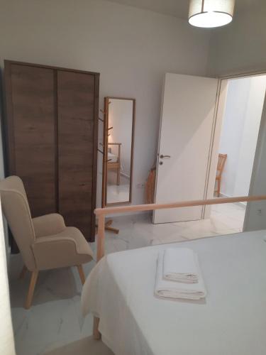 a bedroom with a bed and a chair and a mirror at House B Diavata, Thessaloniki in Thessaloniki