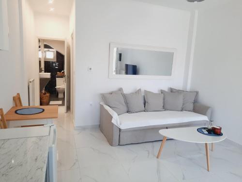 a white living room with a couch and a table at House B Diavata, Thessaloniki in Thessaloniki