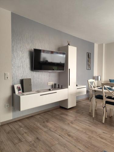 a living room with a television on a wall at Ferienwohnung Bamberger mit Wintergarten Schmalkalden in Schmalkalden