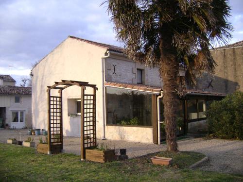 un bâtiment avec une arche à côté d'un palmier dans l'établissement maison de campagne, à Champagnolles