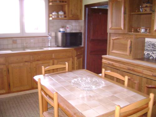 Il comprend une cuisine avec une table et des chaises. dans l'établissement maison de campagne, à Champagnolles