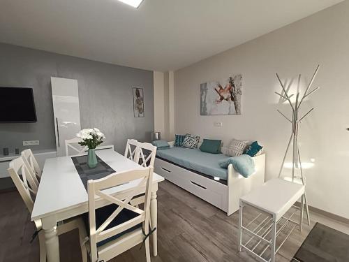 a living room with a couch and a table and chairs at Ferienwohnung Bamberger mit Wintergarten in Schmalkalden