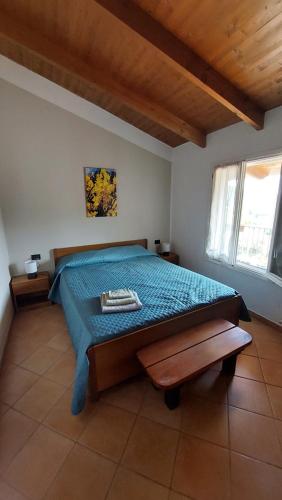 a bedroom with a bed with a blue comforter at Il Nido Del Viaggiatore in Vallebona