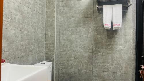 a bathroom with a toilet and towels on a wall at 古北御尚精品民宿Gubeiyushang in Gubeikou