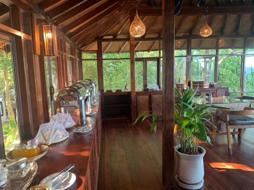 een eetkamer van een huis met een tafel en een plant bij Kohtao Heritage Hideaway in Ko Tao