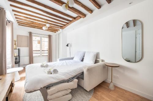 une chambre blanche avec un grand lit et un miroir dans l'établissement Montparnasse - Studio Fully equipped, à Paris