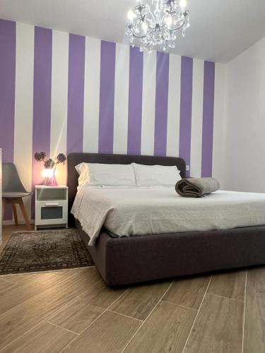 a bedroom with a bed with purple and white stripes at Casa Amelia in Nesso