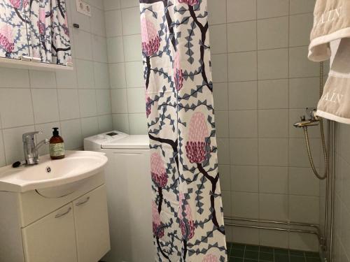 a bathroom with a shower curtain and a sink at Huippukaksio parvekkeella Linnan lähellä in Savonlinna