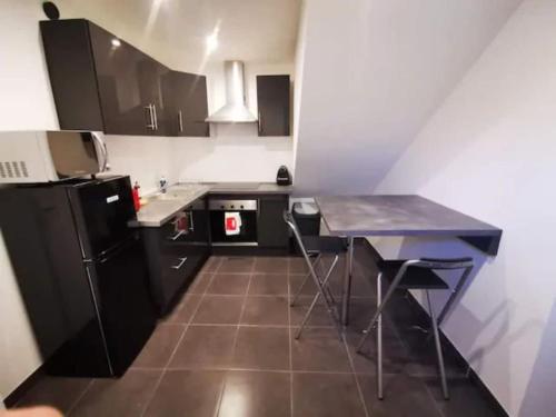 une petite cuisine avec une table et un réfrigérateur dans l'établissement Le QG, à Vienne