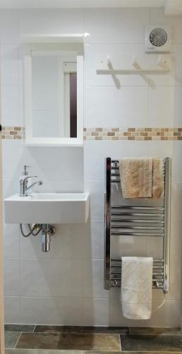 a white bathroom with a sink and a mirror at FOX'S DEN Dog friendly, self-contained guest suite in Lymington