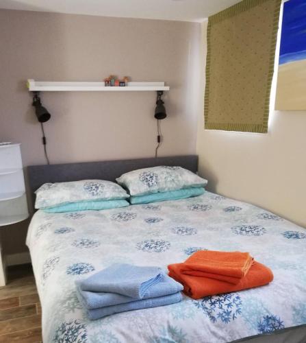 a bedroom with a bed with towels on it at FOX'S DEN Dog friendly, self-contained guest suite in Lymington
