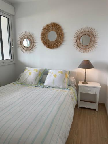 - une chambre avec deux miroirs sur le mur et un lit dans l'établissement Appartement Arcachon vue sur le bassin, à Arcachon